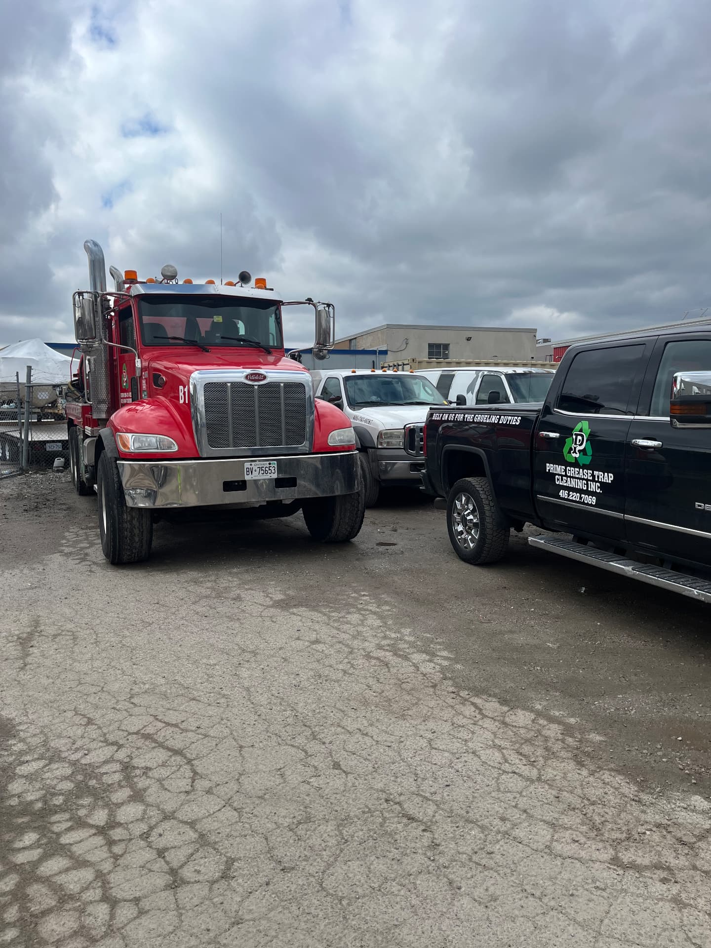 Prime Grease Trap Cleaning Inc. vacuum truck and branded service pickup parked at the yard