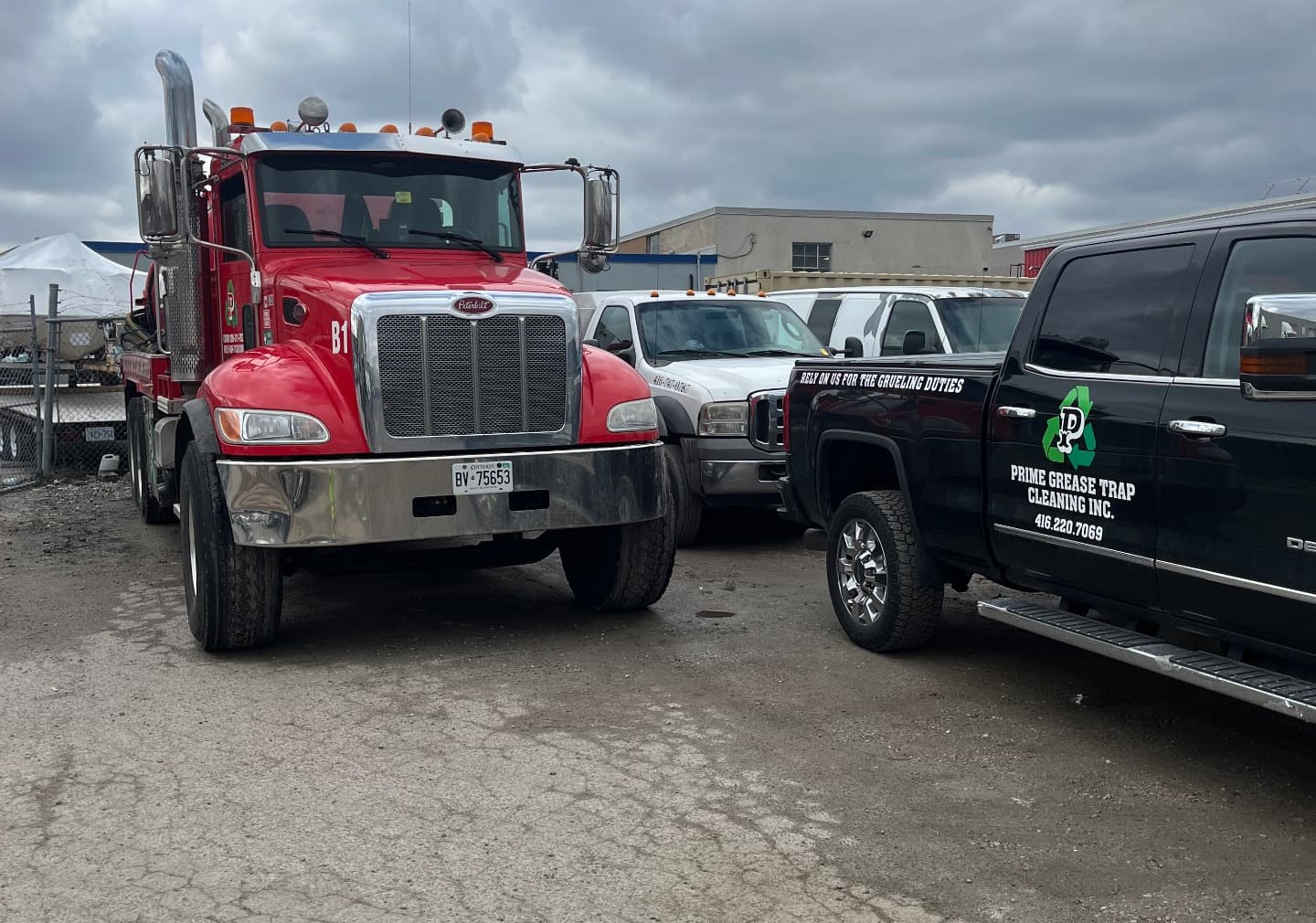Prime Grease Trap Cleaning Inc. red vacuum truck and black service pickup